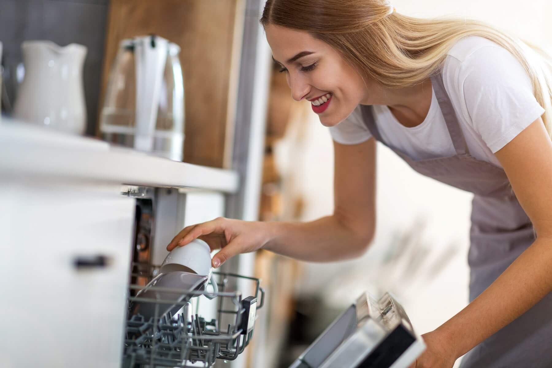 http://A%20woman%20loading%20the%20dish%20washer