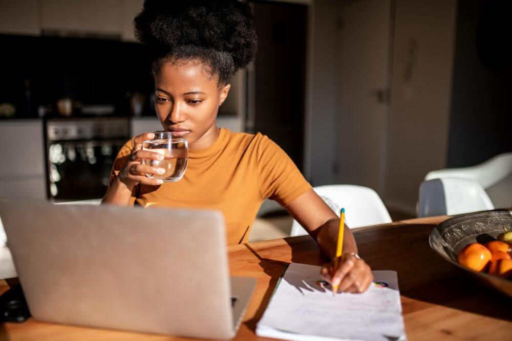 http://Woman%20drinking%20water%20while%20working